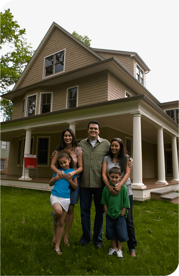 Family standing in front of their house smiling
