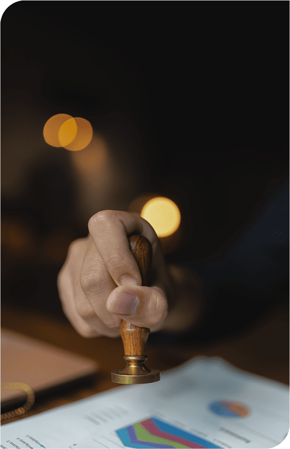 Hand stamping document in dimly lit room.