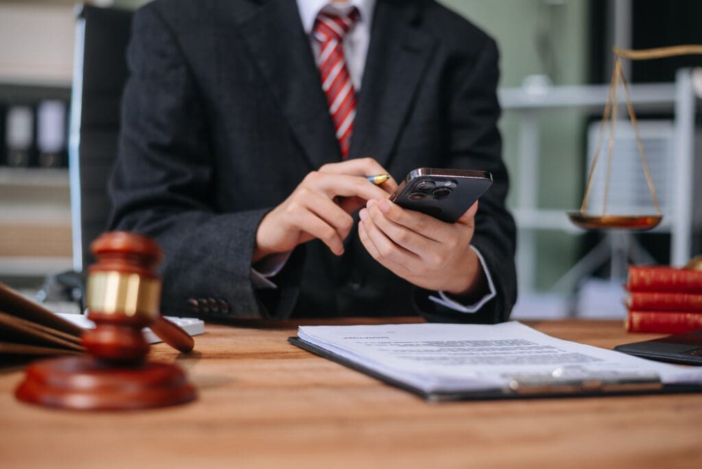 Person in suit using phone at legal desk