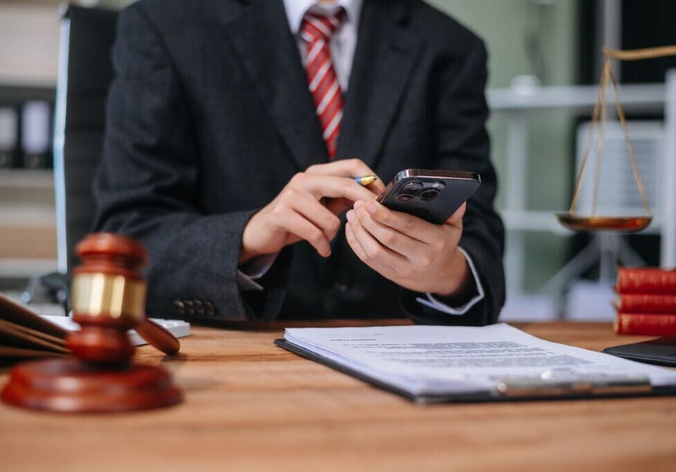 Person in suit using phone at legal desk